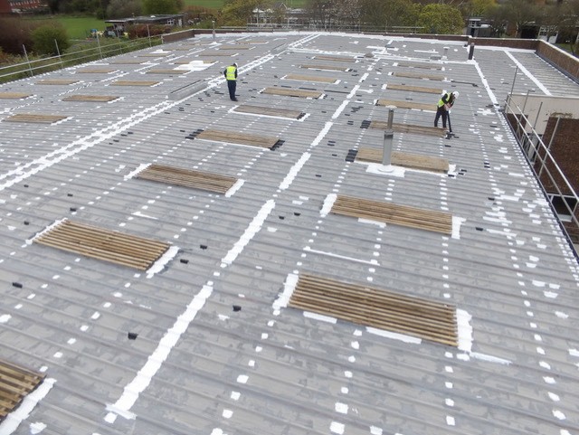 Metal roof being waterproofed and repaired using liquid waterproofing systems